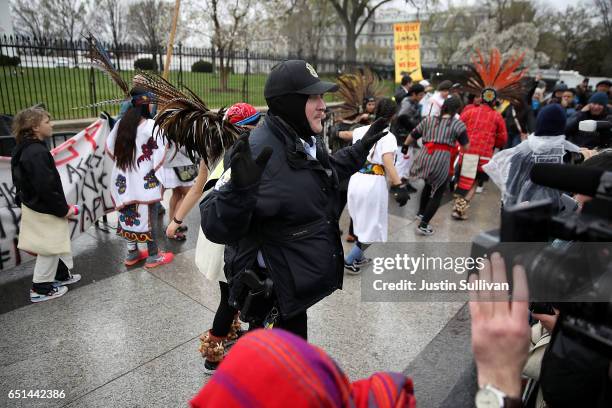 Police officer clears protesters off the sidewalk in front of the White House during a demonstration against the Dakota Access Pipeline on March 10,...