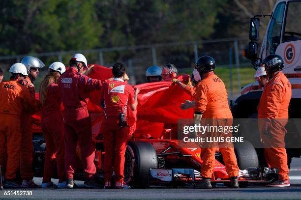 Ferrari's mechanics cover the Ferrari of Finnish driver Kimi Raikkonen at the Circuit de Catalunya on March 10, 2017 in Montmelo on the outskirts of...