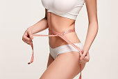 The girl taking measurements of her body, white background