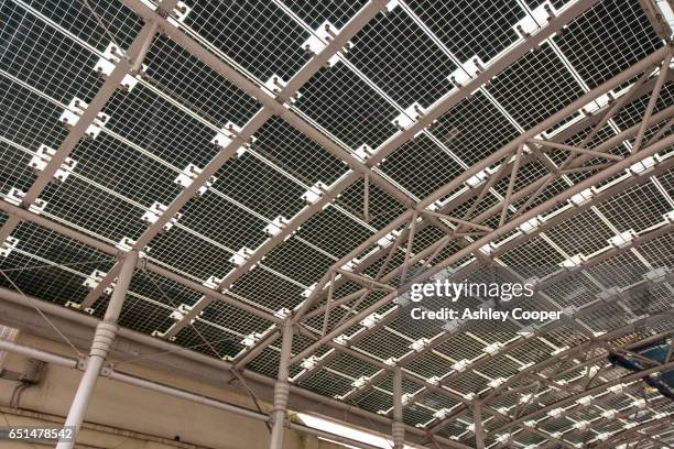 solar panels on an awning over the railway station entrance in woking, surrey, uk. - solar powered station stock pictures, royalty-free photos & images