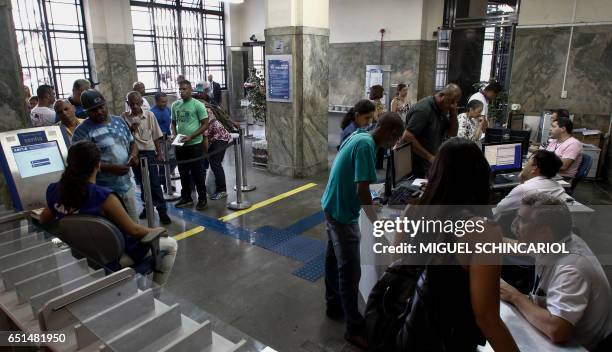 Customers queue in the state-owned Caixa Economica Federal bank to withdraw the indemnity fund for employees , in Sao Paulo, Brazil, on March 10,...