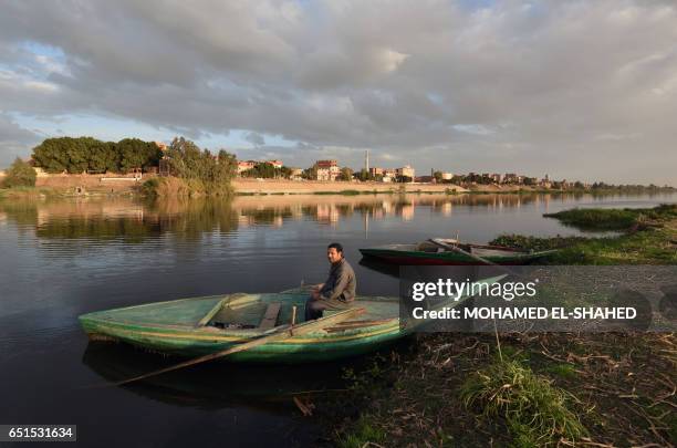 An Egyptian fisherman sits in his boat in the Egyptian Nile Delta province of al-Minufiyah, near the town of Ashmun, on March 10, 2017. / AFP PHOTO /...