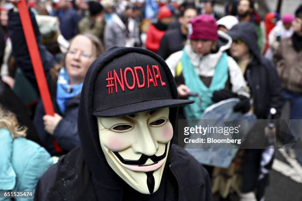 Demonstrator wears a Guy Fawkes mask and #NODAPL hat while participating in a protest against the Dakota Access Pipeline in Washington, D.C., U.S.,...