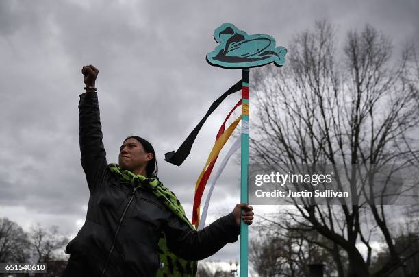 Protester holds a sign during a demonstration against the Dakota Access Pipeline on March 10, 2017 in Washington, DC. Thousands of protesters and...