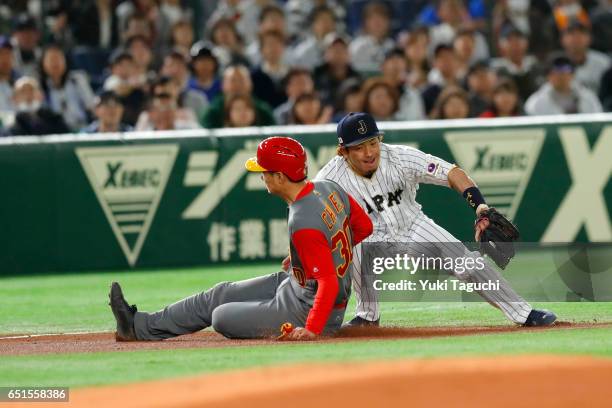 Fujia Chu of Team China slides safely into third base as Nobuhiro Matsuda applies the tag in the first inning during Game 6 of Pool B at the Tokyo...