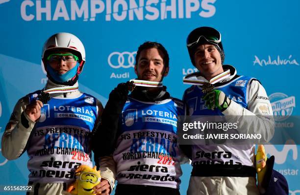 Aerials World Champion 2017 US skier Jonathon Lillis celebrates his victory with silver medallist Chinese skier Guangpu Qi and bronze medallist...