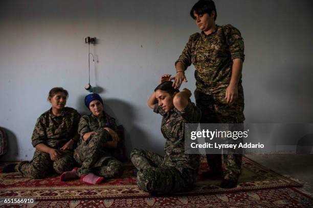 Female YPG fighters Zilan from Qamishlo, has her hair braided by Uzgur from Derek, at a base in the former ISIS and Jabat al Nusra stronghold of Tel...