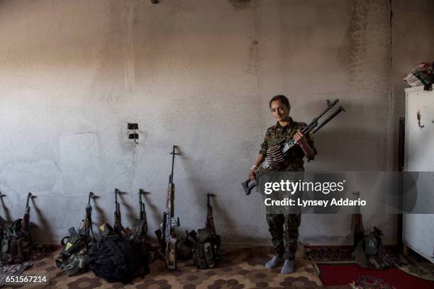 Fighter in training, Variya from Qamishlo, poses for a portrait with the Russian-made PKM she is learning to use at a base in the former ISIS and...