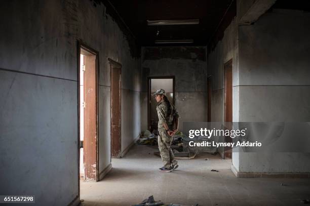 Deniz Derek walks among trash left by ISIS and Jabat al Nusra fighters at one of their former bases in an abandoned school in the now ghost-town of...