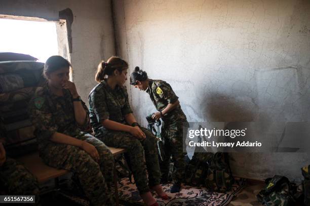 Fighter in training, Nuda from Qamishlo, picks up her gun to pose for a portrait in the former ISIS and Jabat al Nusra stronghold of Tel Bark, which...