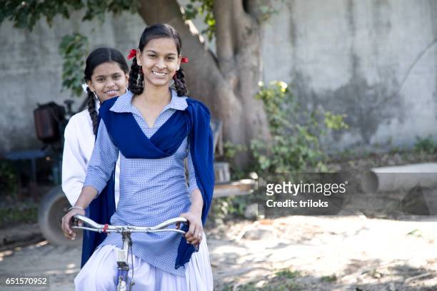 schoolgirls on bicycle - rural scene stock pictures, royalty-free photos & images