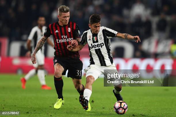 Paulo Dybala of Juventus FC competes with Juraj Kucka of AC Milan during the Serie A match between Juventus FC and AC Milan at Juventus Stadium on...