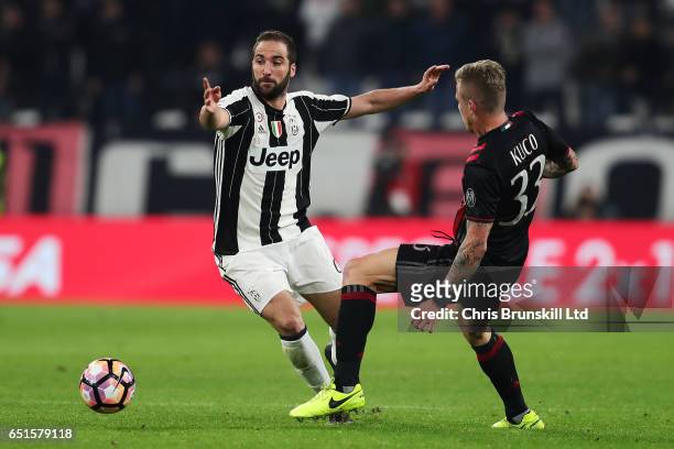 Gonzalo Higuain of Juventus FC is challenged by Juraj Kucka of AC Milan during the Serie A match between Juventus FC and AC Milan at Juventus Stadium...