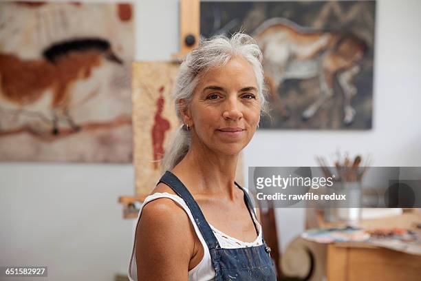 a femail artist in her studio - donne mature foto e immagini stock