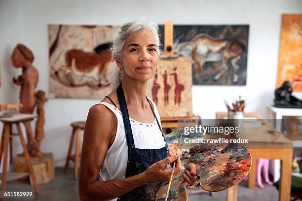 a femail artist in her studio - making painting stock-fotos und bilder