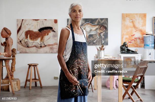 a femail artist in her studio - apron woman photos et images de collection