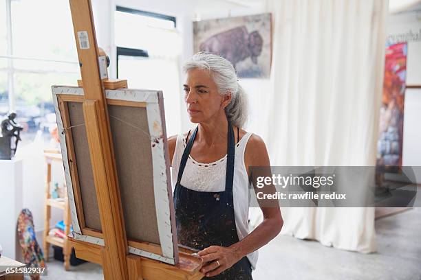 a femail artist in her studio - female artist painting stock-fotos und bilder