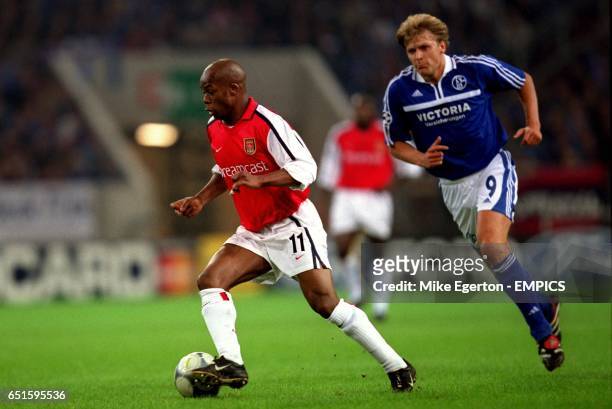 Arsenal's Sylvain Wiltord takes the ball away from Schalke 04's Youri Mulder