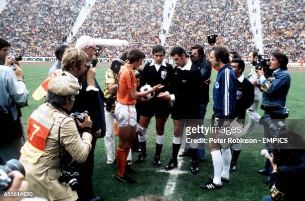 Holland captain Johan Cruyff checks to see the outcome of the toss, watched by West Germany captain Franz Beckenbauer and referee Jack Taylor