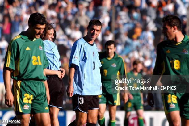 Australia's John Aloisi and Paul Agostino stand dejected as Alejandro Lembo celebrates Uruguay's win