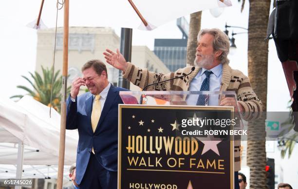 Actor John Goodman reacts as actor Jeff Bridges speaks at Goodman's star unveiling ceremony on the Hollywood Walk of Fame, March 10 in Hollywood,...
