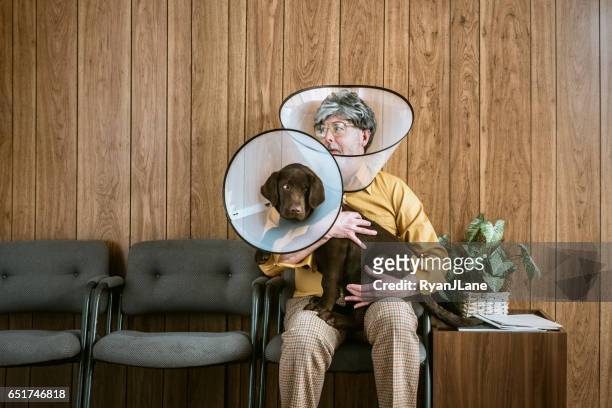uomo al veterinario che indossa il cono del cane - bizzarro foto e immagini stock