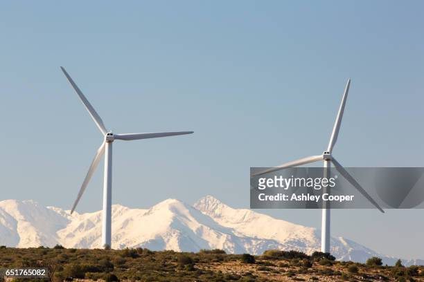 wind turbines near opoul in the south of france with the snow covered pyranean mountains behind. - occitanie - fotografias e filmes do acervo