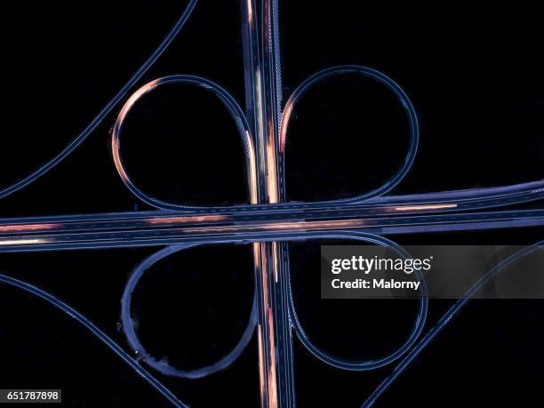 highway or autobahn at night. long exposure, top view. - flyovers stock pictures, royalty-free photos & images