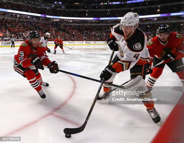 Cam Fowler of the Anaheim Ducks looks to pass under pressure from Jonathan Toews of the Chicago Blackhawks at the United Center on March 9, 2017 in...
