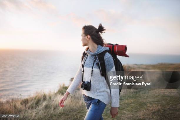 girl on cliff walking near ocean - blue sweater stockfoto's en -beelden