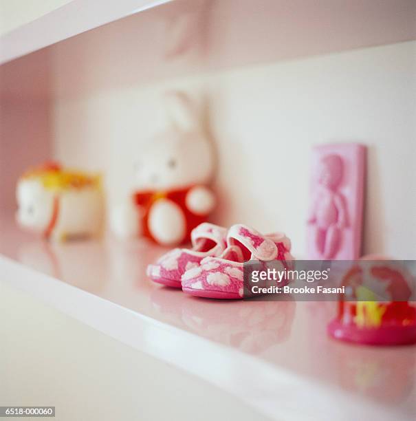 baby shoes on shelf - babyschuhe stock-fotos und bilder
