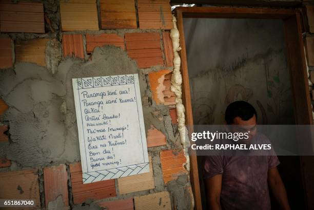 Chief Joilson Paulino of the Karapana indigenous group walks by a sign reading "good morning" in Portuguese, Spanish, English and eight indigenous...