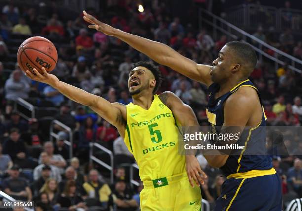 Tyler Dorsey of the Oregon Ducks drives to the basket against Kingsley Okoroh of the California Golden Bearsduring a semifinal game of the Pac-12...