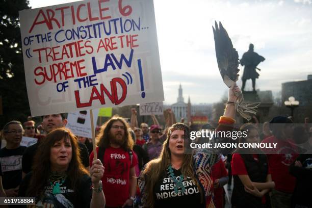 Native Americans and indigenous rights activists march and hold up signs in protest during a Native Nations March in Denver, Colorado on March 10,...