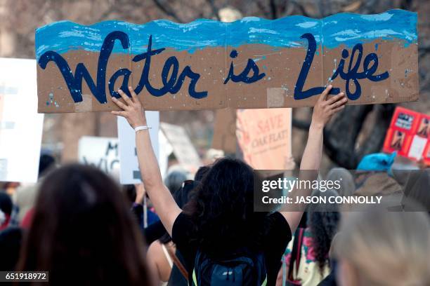 Native Americans and indigenous rights activists march and hold up signs in protest during a Native Nations March in Denver, Colorado on March 10,...