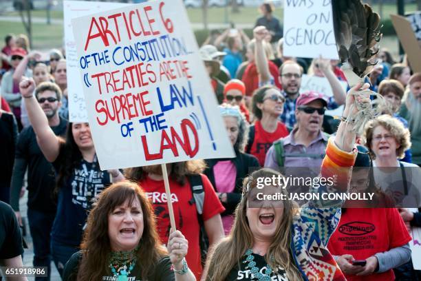 Native Americans and indigenous rights activists march and hold up signs in protest during a Native Nations March in Denver, Colorado on March 10,...