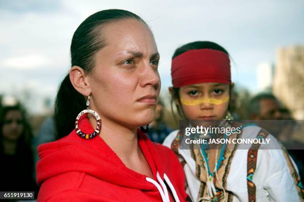 Young native American and his mother look on during a Native Nations March in Denver, Colorado on March 10, 2017. Native tribes from around the US...