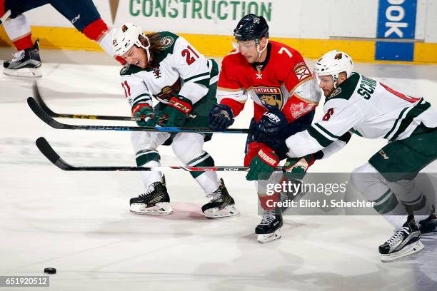 Colton Sceviour of the Florida Panthers tangles with Marco Scandella and Ryan White of the Minnesota Wild at the BB&T Center on March 10, 2017 in...