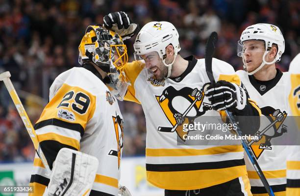 Justin Schultz and goalie Marc-Andre Fleury of the Pittsburgh Penguins celebrate their shootout victory against the Edmonton Oilers on March 10, 2017...
