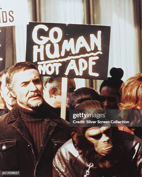 Actor Ricardo Montalban as Armando and Roddy McDowall as Caesar in 'Conquest of the Planet of the Apes', 1972. Behind them a sign reads 'Go Human Not...