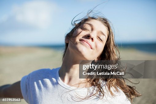 Young woman with eyes closed smiling on a beach Young woman with eyes closed smiling on a beach