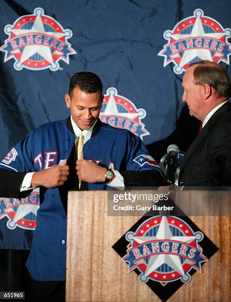 Alex Rodriguez tries on his new Texas Rangers jersey presented to him by club owner Tom Hicks during a press conference introducing him to the media...