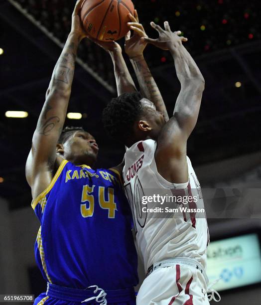 Darnell Tillman of the UKMC Kangaroos and Jemerrio Jones of the New Mexico State Aggies battle for a rebound during a semifinal game of the Western...