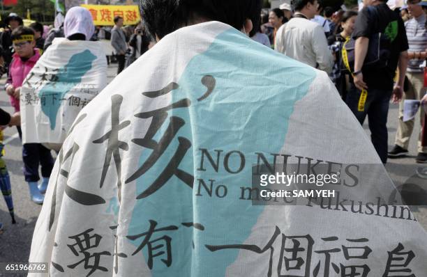 Anti-nuclear protesters carry the anti-nuclear banners during a demonstration in front of the Presidential Palace in Taipei on March 11, 2017....