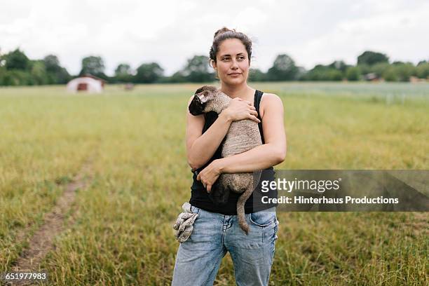 farmer standing in field with lamb - sleeveless ストックフォトと画像