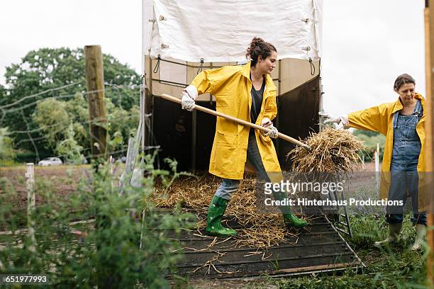 organic farmer cleaning trailer - frau mit gelben regenmantel stock-fotos und bilder