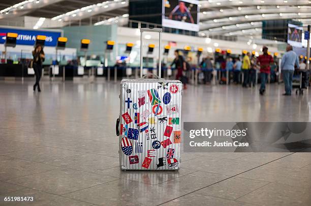 unattended suitcase in departure zone at airport - bagagli foto e immagini stock