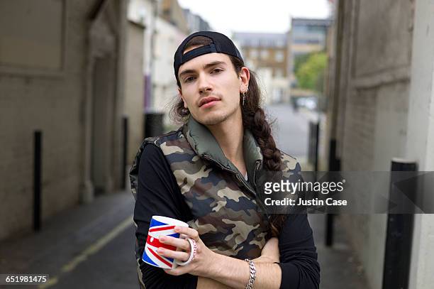 Portrait of a young man holding British flag cup
