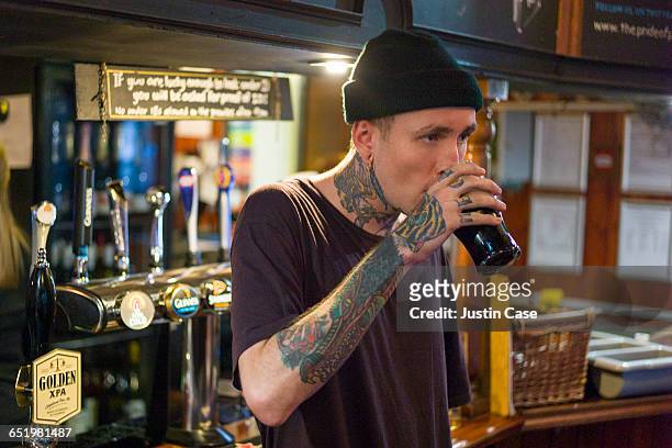 man having a pint in the pub - hipster persona foto e immagini stock