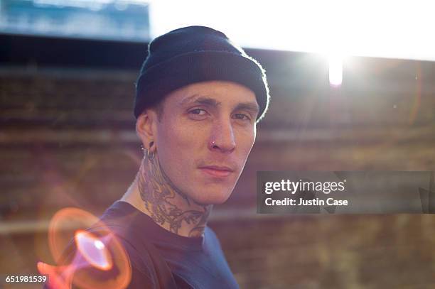 portrait of tattoed man shot from behind - opstand stockfoto's en -beelden